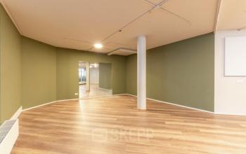 Spacious office interior at De Boelelaan 1110, Amsterdam Zuidas featuring wooden floors and green walls, ideal for office space rental.