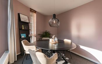 Cozy office space rental in Amsterdam Zuidas with a round table and modern chairs, ideal for collaborative meetings or discussions.