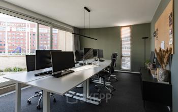 Bright office space for rent at De Boelelaan 1110, Amsterdam Zuidas, featuring large windows, modern workstations, and a corkboard for brainstorming.