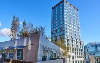 Exterior view of a modern office building at Hildegard Von Bingenstraat 44, Amsterdam Zuidas, with a unique facade and rooftop greenery. Ideal for those seeking office space rental in a vibrant location.