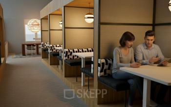 Cozy office space rental at Barbara Strozzilaan 101 101 in Amsterdam Zuidas, featuring booth seating with two people engaged in business activities.