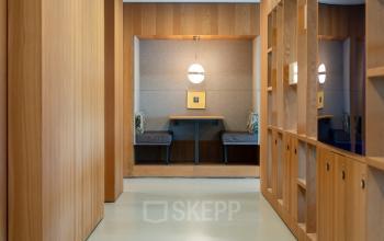 Modern hallway at Barbara Strozzilaan 101, Amsterdam Zuidas, featuring sleek wood paneling and built-in storage, ideal for office space rental.