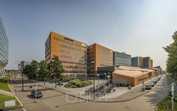Exterior view of office buildings at Jachthavenweg 109, Amsterdam Zuidas, showing a modern design with a nearby bike parking area.