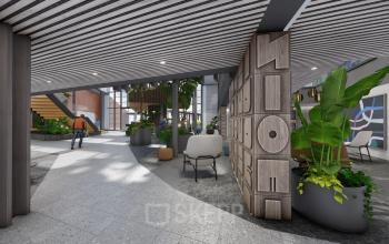 Modern office space in Amsterdam Zuidas with stylish decor and greenery, featuring a man walking. Ideal for rent, offering a dynamic environment for professionals.