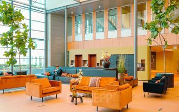 Spacious and bright office lounge at Jachthavenweg 109, Amsterdam Zuidas, offering comfortable seating with modern furnishings, ideal for informal meetings. Consider this vibrant office space rental for your next business move.
