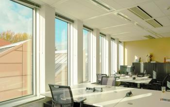 Bright, furnished office space rental in Amsterdam Zuidas with large windows and multiple workstations ready for use.