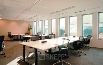 Bright and airy office space available for rent at Jachthavenweg 109, Amsterdam Zuidas, featuring multiple workstations with ergonomic chairs and large windows for natural light.