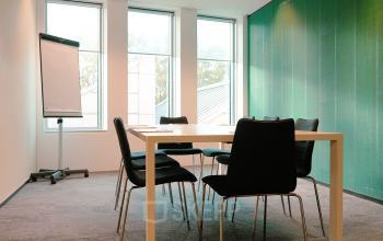 Well-lit office space at Jachthavenweg 109, Amsterdam Zuidas, featuring a table and chairs, ideal for meetings. Perfect for anyone seeking office space rental in a professional setting.