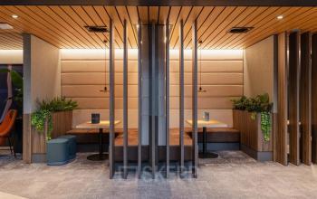 Modern furnished office space at Jachthavenweg 109, Amsterdam Zuidas, featuring cozy seating booths and greenery. Perfect for office space rental.