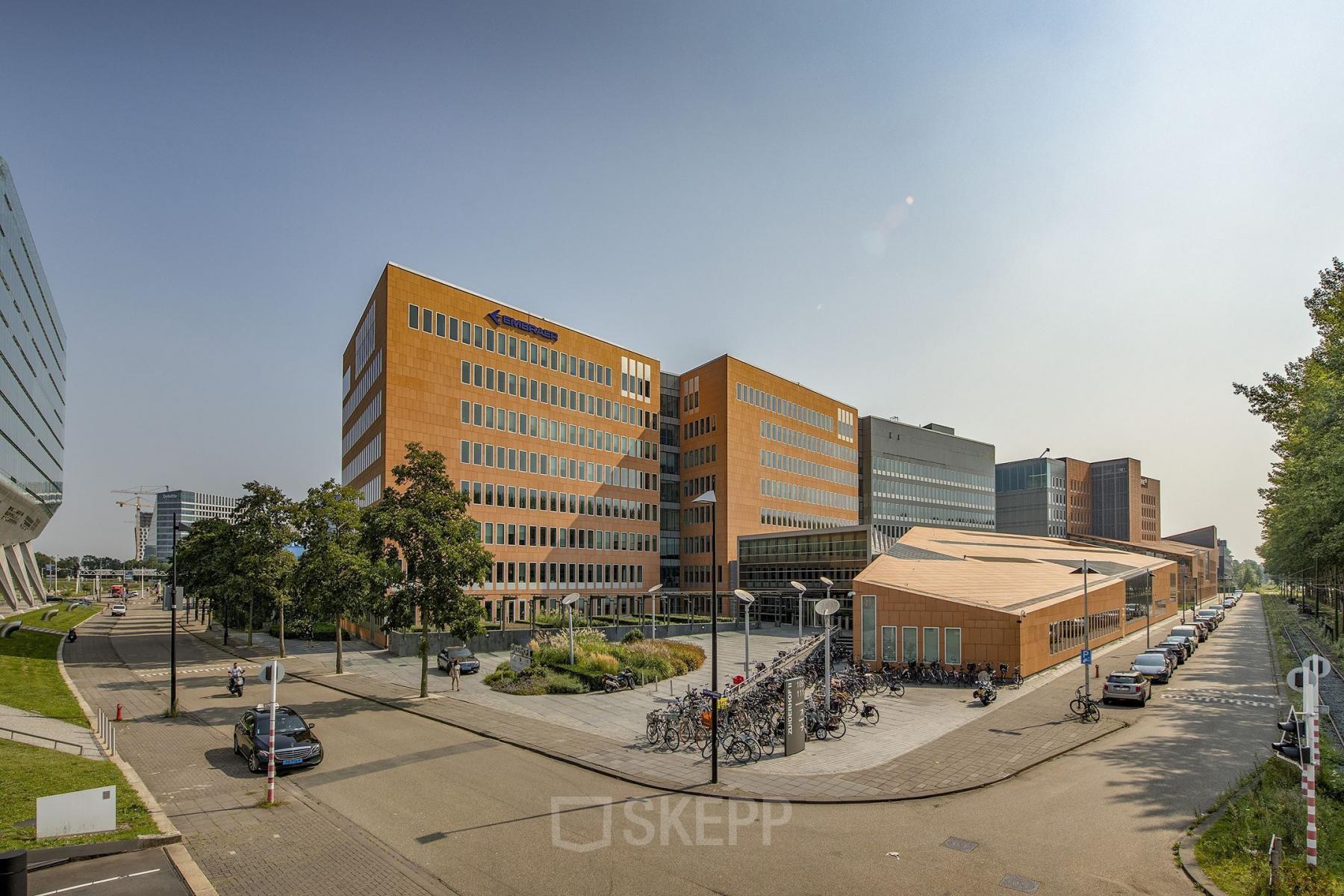 Exterior view of office buildings at Jachthavenweg 109, Amsterdam Zuidas, showing a modern design with a nearby bike parking area.