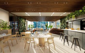 Modern office space in Amsterdam Zuidas with a stylish lounge area, featuring marble tables, wooden chairs, and indoor plants ideal for office space rental.