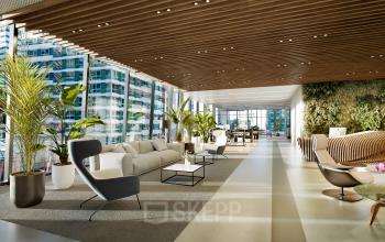 Modern, furnished office space with large windows, offering a vibrant view in Amsterdam Zuidas. Ideal for those looking to rent office space with a comfortable lounge area and abundant natural light.