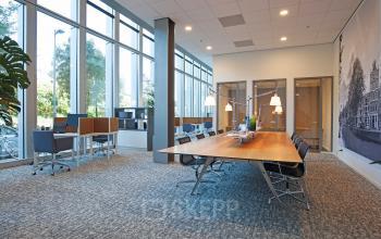 Modern and spacious office to rent at Gustav Mahlerplein 2 in Amsterdam Zuidas, featuring large windows, stylish furnishings, and a collaborative workspace.