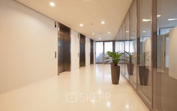 Bright hallway with elevators at Gustav Mahlerplein 2, Amsterdam Zuidas, ideal for office space rental.