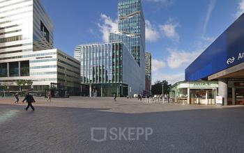 Exterior view of the office located at Gustav Mahlerplein 2, in Amsterdam Zuidas, Amsterdam, showcasing a modern skyline and nearby facilities in a bustling plaza.