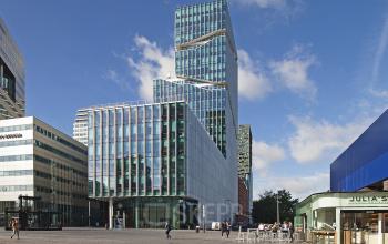 Modern exterior of Gustav Mahlerplein 2 office building in Amsterdam Zuidas with glass facade and surrounding cityscape.