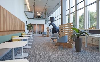 Spacious, modern office for rent at Gustav Mahlerplein 2, Amsterdam Zuidas, featuring contemporary furnishings, floor-to-ceiling windows, and a bright atmosphere with tables, chairs, and plants.