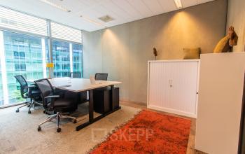 Bright and modern office space for rent in Amsterdam Zuidas with contemporary furnishings and large windows providing city views.
