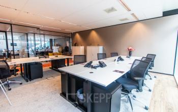 Modern furnished office space at Claude Debussylaan 7-29 in Amsterdam Zuidas, featuring sleek desks and chairs ready for office space rental.