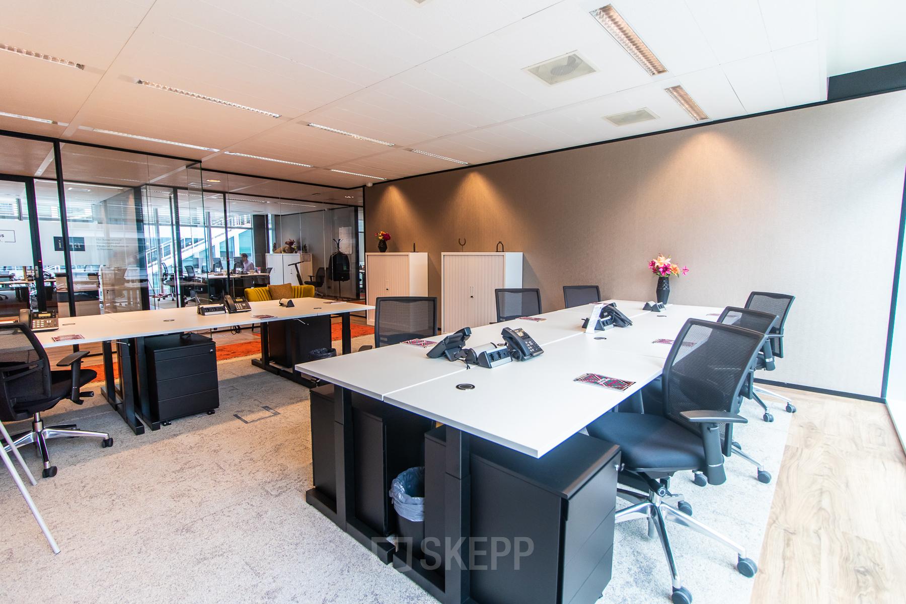 Modern furnished office space at Claude Debussylaan 7-29 in Amsterdam Zuidas, featuring sleek desks and chairs ready for office space rental.