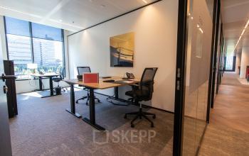 Modern office space rental at Gustav Mahlerlaan 1212, Amsterdam Zuidas, featuring spacious desks, ergonomic chairs, and large windows with city views.
