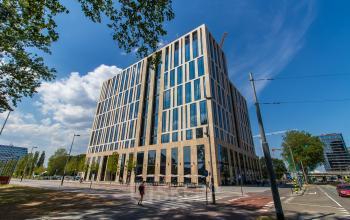 Modern office building at Gustav Mahlerlaan 1212 in Amsterdam Zuidas, designed with tall windows and a beige facade. Ideal for office space rental, located in a bustling business district.