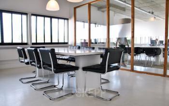 vergaderruimte tafel stoelen lampen glazen wand presentatie