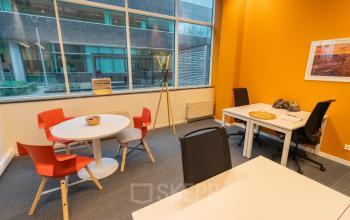 Kantoorruimte te huur in Antwerpen Berchem, gelegen op Uitbreidingstraat 84, met moderne meubels, grote ramen en helder verlichte werkplekken, ideaal voor zakelijke activiteiten.