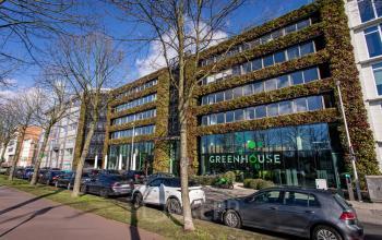 Kantoorruimte te huur aan de Uitbreidingstraat 66 in Antwerpen Berchem, modern kantoorpand met groene gevel en voorgevel met parkeerplaatsen.