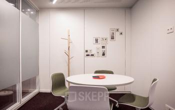 Kantoorruimte te huur aan Uitbreidingstraat 66, Antwerpen Berchem met een stijlvolle vergadertafel en vier moderne stoelen.