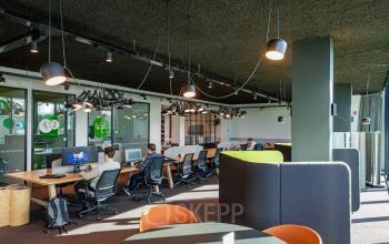 Moderne kantoorruimte te huur aan de Uitbreidingstraat 66, Antwerpen Berchem, met diverse werkplekken en mensen aan het werk achter computers.