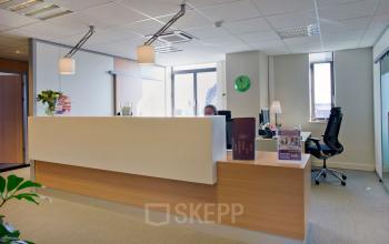 Modern reception desk with a sleek design and office chair in a professional workspace at De Keyserlei 58-60, Antwerp Centre, available for office space rental.