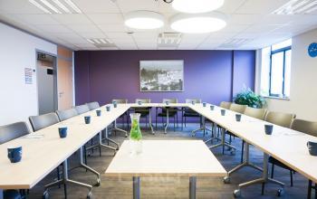 Conference room at De Keyserlei 58-60, Antwerp Center with modern furnishings, U-shaped table setup, and natural light from large windows, ideal for office space rental.