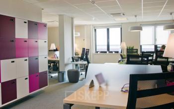 Modern office space with desks, chairs, and colorful storage lockers at De Keyserlei 58-60 in Antwerp Center, available for office space rental.
