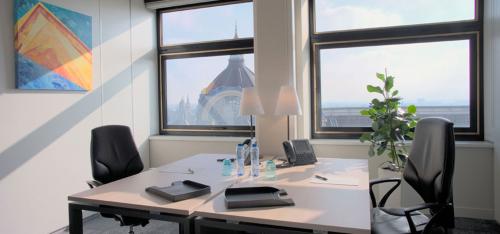 Bright office space at De Keyserlei 58-60 in Antwerp Centre featuring large windows with city views and modern furnishings, ideal for office space rental.