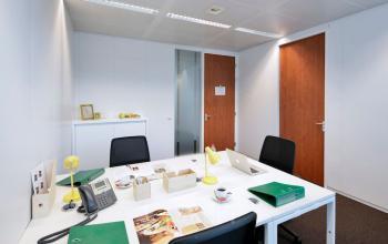 Interior office space at Lange Lozanastraat 142, Antwerp Center, featuring a furnished workspace with a white table, office chairs, and various desk items ideal for office space rental.
