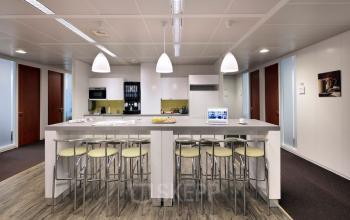 Modern office kitchen space at Lange Lozanastraat 142 in Antwerp Center, featuring a sleek counter with bar stools, ideal for office space rental.