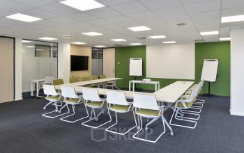 Vergaderruimte op Noorderlaan 147 in Antwerpen Merksem met moderne witte tafels en stoelen, klaar voor gebruik. Geschikt voor kantoor te huur of kantoorruimte huren.