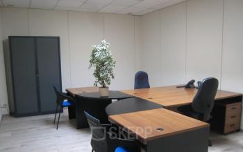 Office space rental at Boomsesteenweg 690 in Antwerp Wilrijk featuring modern desks, chairs, and a plant.