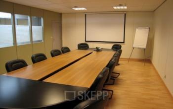 Spacious conference room with a long table and leather chairs in office space rental at Boomsesteenweg 690, Antwerp Wilrijk.