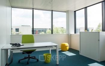 Kantoorruimte te huur in Antwerpen Wommelgem, Nijverheidsstraat 70. Moderne ruimte met een bureau, bureaustoel en opbergkast. Grote ramen zorgen voor veel natuurlijk licht.
