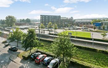 Exterior view of office building located at Linie 580-596, Apeldoorn, with surrounding parking area and greenery.