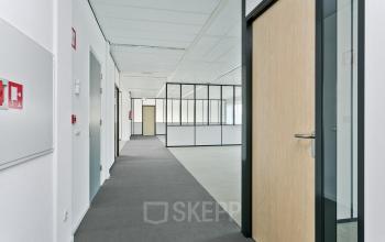 Interior office space at Linie 580-596 in Apeldoorn featuring a corridor with multiple doors and glass-walled rooms for office space rental.