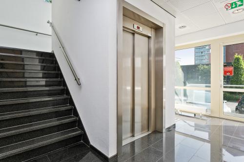 Bright interior of an office building in Apeldoorn at Linie 580-596, showing an elevator and stairs with large windows that allow natural light.