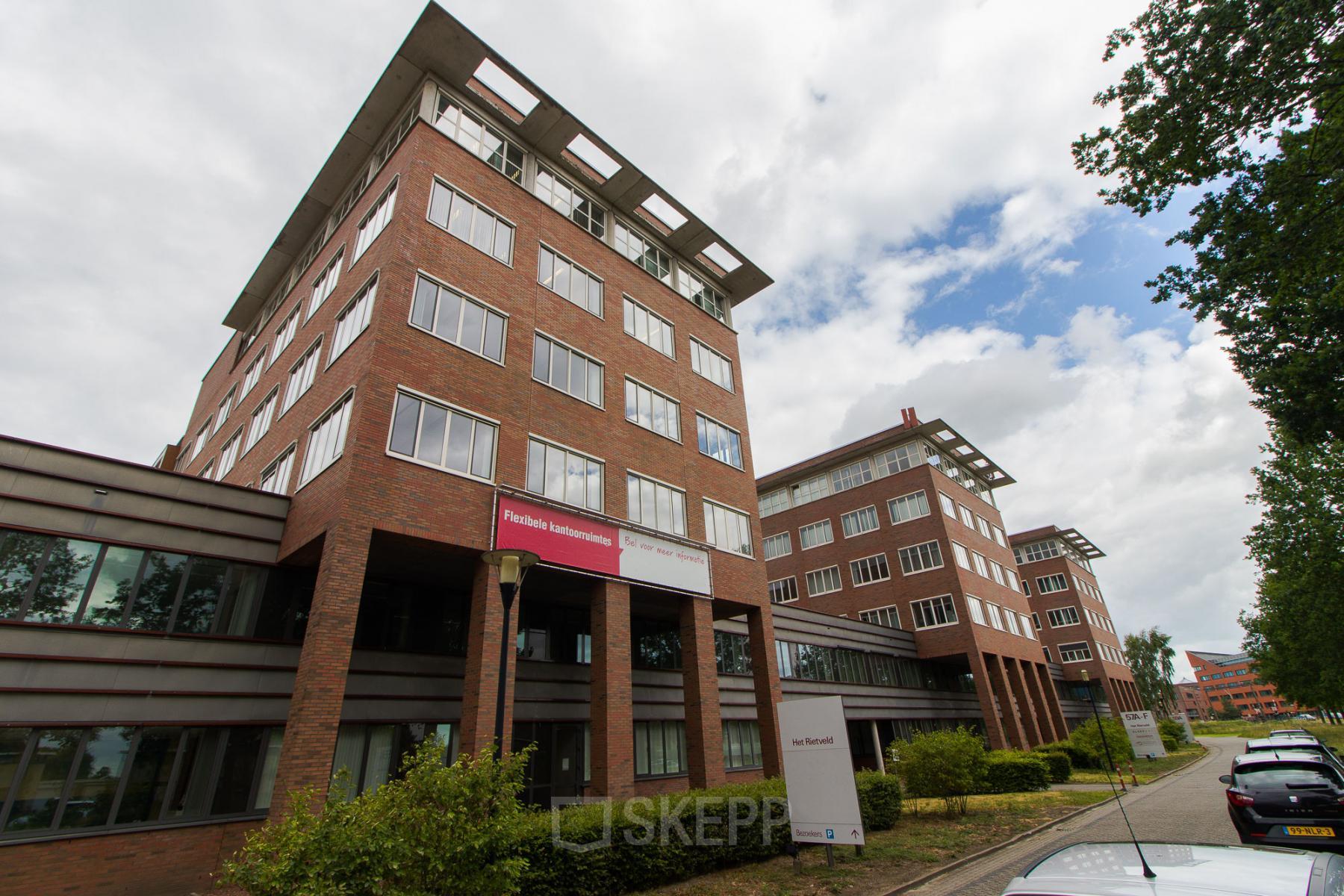 Modern office space rental at Het Rietveld 55A in Apeldoorn with a brick exterior and large windows.