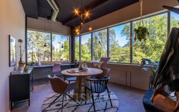 Bright office space at Landdrostlaan 51, Apeldoorn, featuring a large window, modern lighting, and stylish furnishings, available for rent as a workspace.