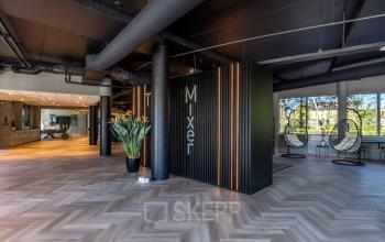 Spacious office interior at Landdrostlaan 51, Apeldoorn, featuring modern design elements, planters, and natural light, ideal for office space rental.