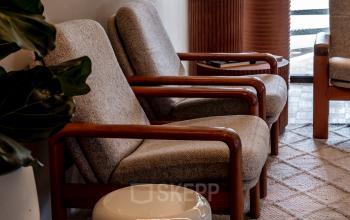 Cozy waiting area with comfortable chairs, decorative plants, and stylish tables at an office to rent in Lange Amerikaweg, Apeldoorn.