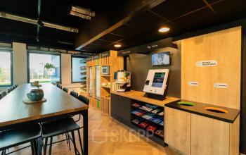 Modern office space rental at Prins Willem Alexanderlaan 701 in Apeldoorn, featuring a furnished pantry area with snacks and coffee machines.