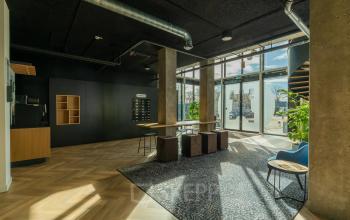 Bright office space in Apeldoorn with large windows, modern furnishings, and natural light streaming in. Ideal for those seeking office space rental at Prins Willem Alexanderlaan 701.